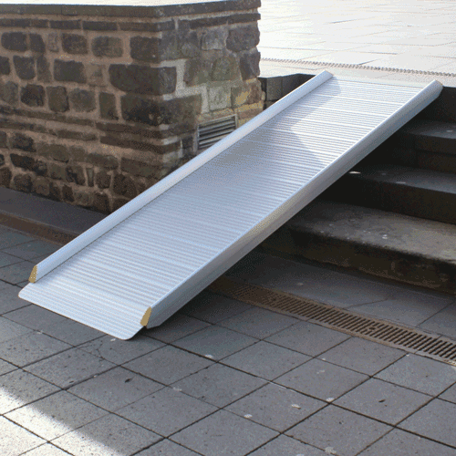 Silberne Flächenrampe positioniert über Treppe mit vier Stufen.