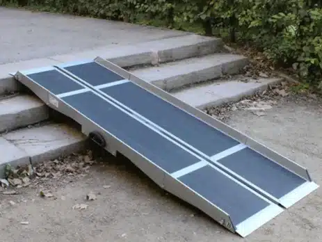 Aluminium-Rampe für barrierefreien Zugang, auf Treppe positioniert, mit rutschfester Oberfläche und seitlicher Kante.