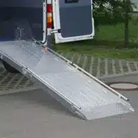 Flächenrampe für den barrierefreien Zugang zu einem Fahrzeug, mit rutschfester Oberfläche und seitlichen Führungsschienen.