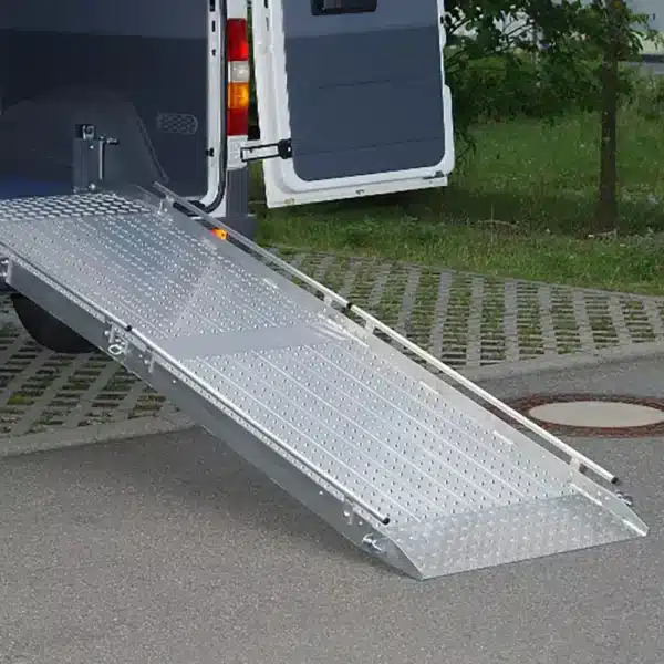 Flächenrampe für den barrierefreien Zugang zu einem Fahrzeug, mit rutschfester Oberfläche und seitlichen Führungsschienen.