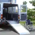 Barrierefreier Transporter mit offenem Heck und ausziehbarer Rampe, bereit für den Ein- und Ausstieg eines Rollstuhls.