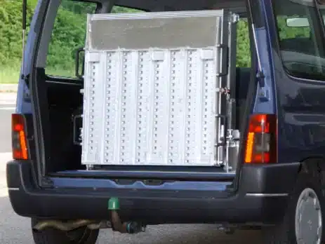 Rückansicht eines Lieferwagens mit einer zusammengeklappten Rampe aus Metall im Laderaum.
