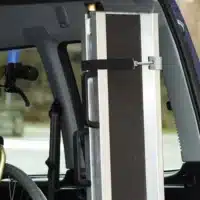 Eine geklappte Rollstuhlrampe steht zusammengeklappt senkrecht im Hinterraum eines Autos.