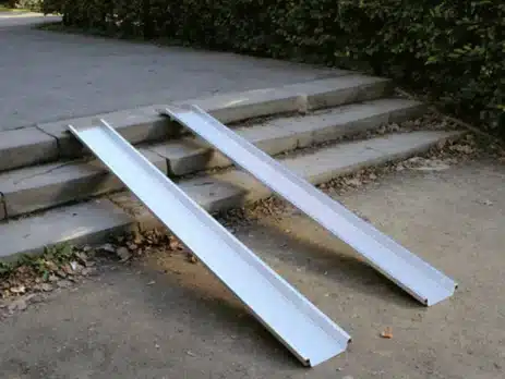 Zwei Aluminium-Rampen liegen an einer Treppe, um den Zugang für Rollstühle zu ermöglichen.
