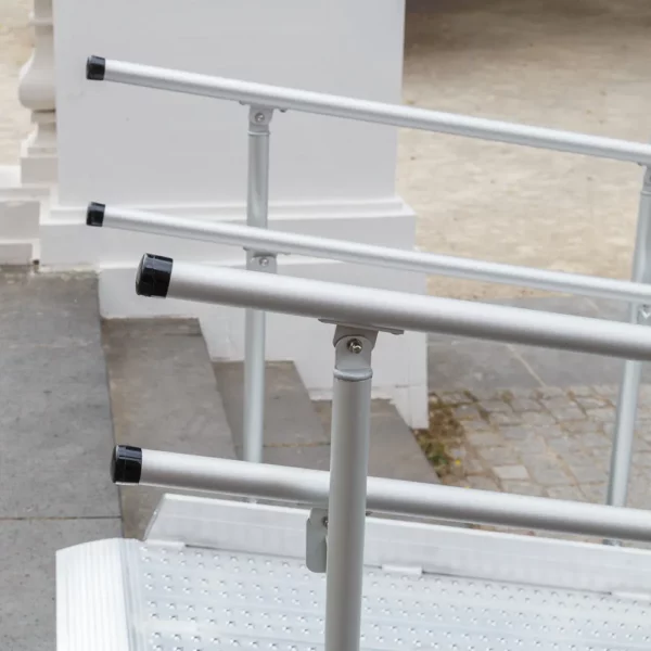 Nahaufnahme einer Rollstuhlrampe aus Aluminium mit Handläufen