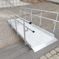 Eine Rollstuhlrampe aus Metall mit Handläufen