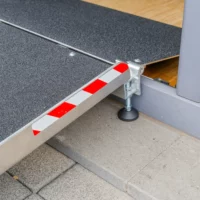 Eine rot-weiß gestreifte Markierung an einer Balkon- und Terrassenbrücke für Rollstuhlfahrer