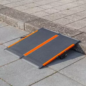 Eine tragbare schwarz-orangefarbene Rollstuhlrampe