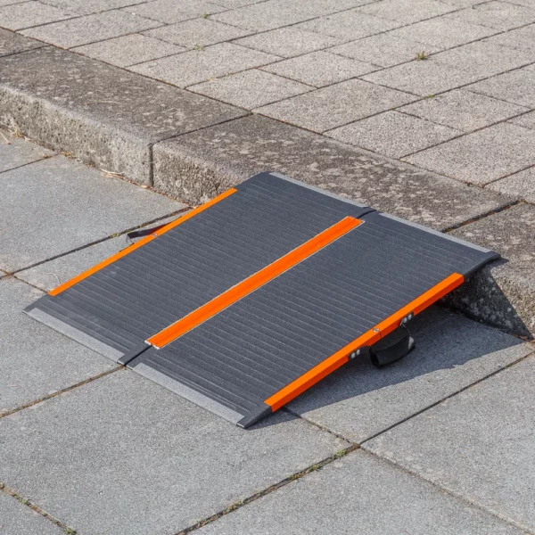 Eine tragbare schwarz-orangefarbene Rollstuhlrampe