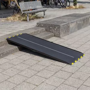 Eine schwarze Rollstuhlrampe aus Carbon mit gelben Rändern