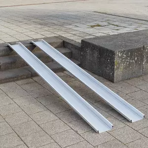 Zwei Schienen einer Rollstuhlrampe aus Aluminium ist über einer Betontreppe im Außenbereich platziert.