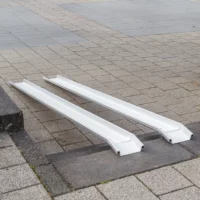 Zwei Schienen einer Rollstuhlrampe ist über einer Betontreppe im Außenbereich platziert