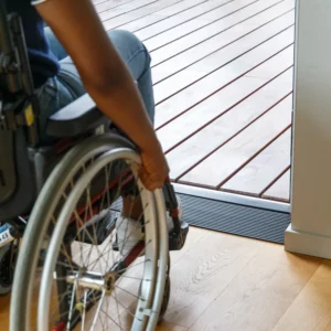 Eine Person im Rollstuhl nähert sich einer Tür