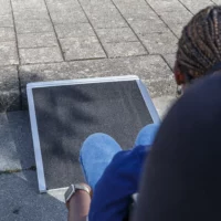 Eine Person im Rollstuhl nähert sich einer tragbaren Rampe