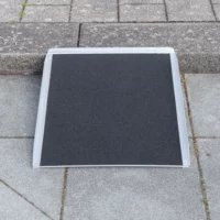 Eine tragbare Rollstuhlrampe auf einem Bordstein