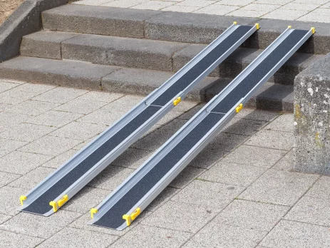 Eine zweiteilige Rollstuhlrampe mit schwarzer Oberfläche